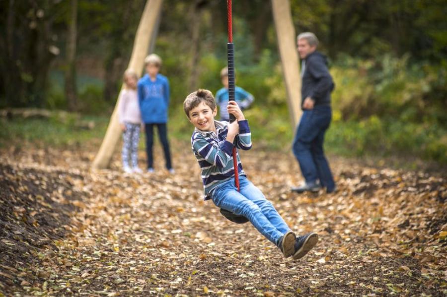 on the swings in the woodland playground at St Ives Holiday Village