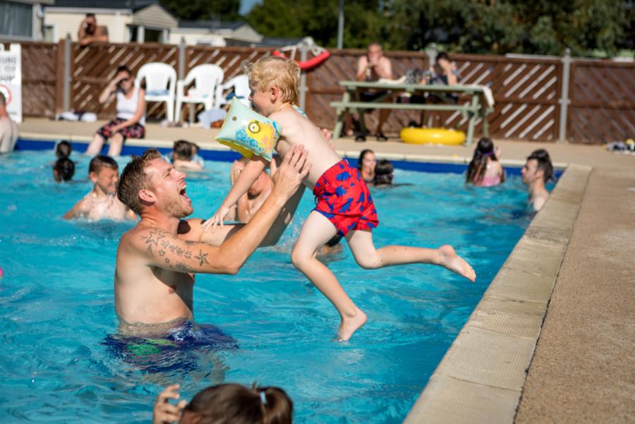 jumping in the outdoor pool on holiday at Carlton Meres Holiday Park