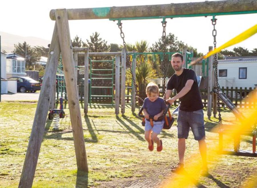 on the swings on holiday at Barmouth Bay Holiday Park