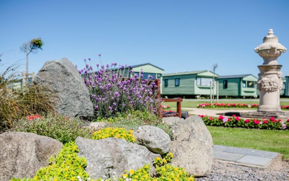 Holiday homes surrounded by flowers/ plants and statue ornaments